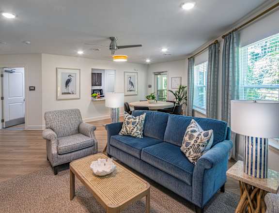 A living room with a blue couch and a grey armchair.