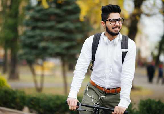 portrait of a young man riding a bike in a park