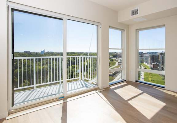 a living room with large windows and a view of the city at Riverhouse Apartments, Fargo, North Dakota 58102