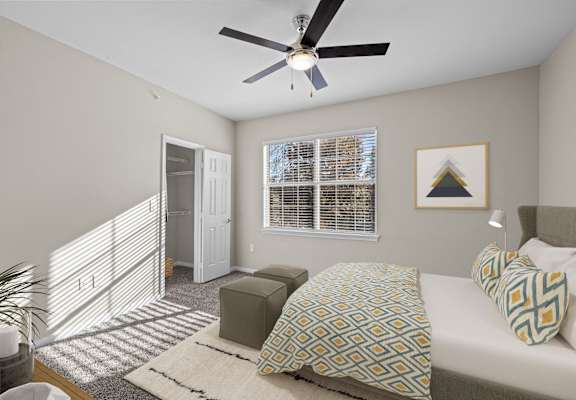 a bedroom with a large bed and a ceiling fan