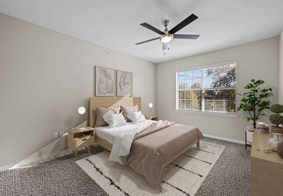 a bedroom with a large bed and a ceiling fan