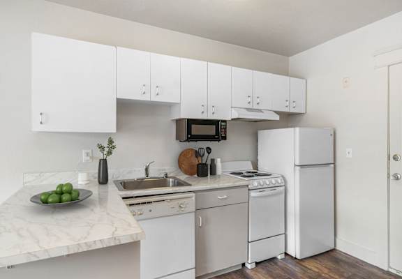A kitchen with white appliances and cabinets.
