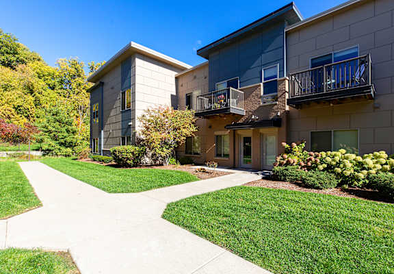 A building with a balcony and a walkway in front of it.