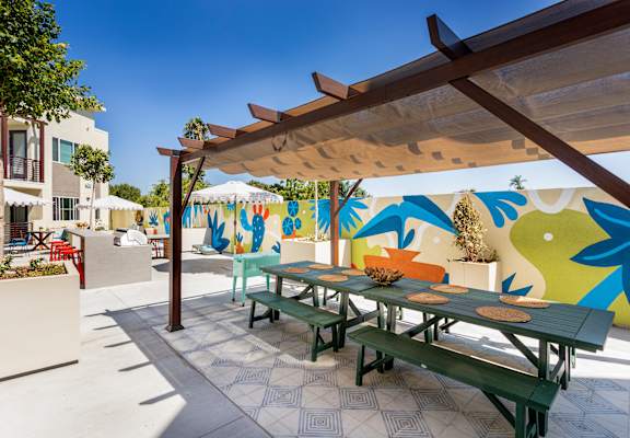 A colorful mural on a wall behind a picnic table. at The Reserve La Mirada, California