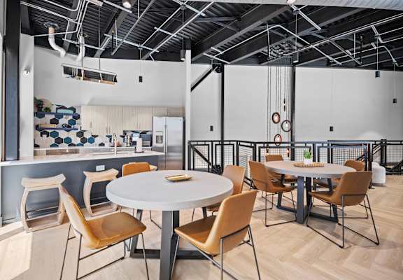 a dining room with tables and chairs and a kitchen