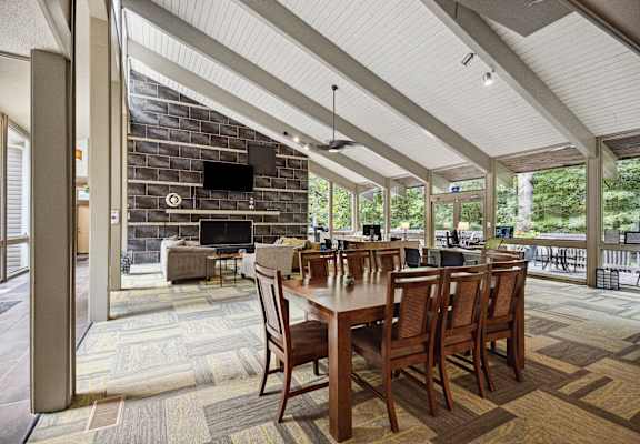a covered patio with a fireplace and a dining table