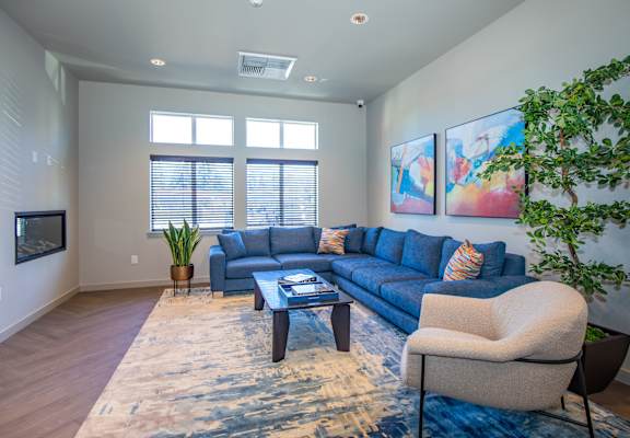 A living room with a blue couch, a coffee table, and a rug.