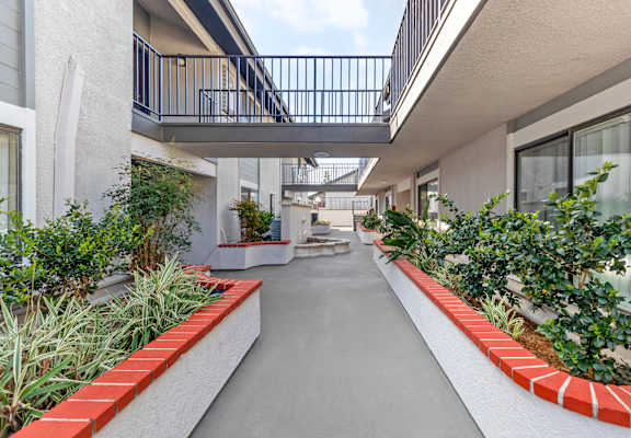 a corridor with benches and plants at an apartment building
