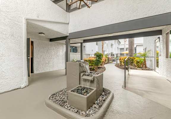 a lobby with a water fountain in the middle