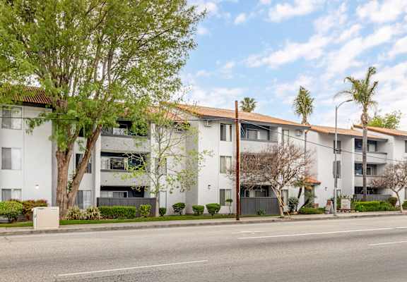 a white apartment building with a street in front of it