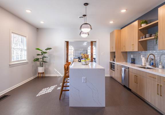 a kitchen with a white island and wooden cabinets