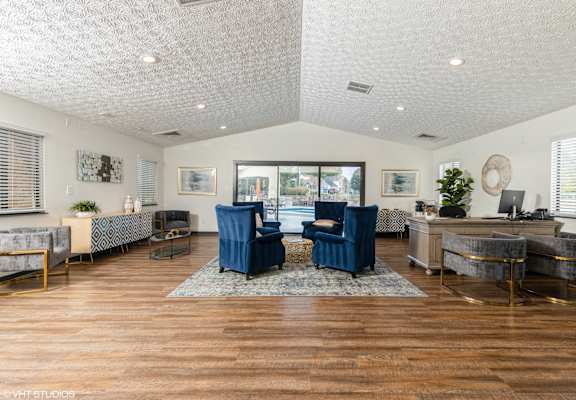 a living room with blue chairs and a large window at Springburne at Polaris Apartments, Columbus, OH