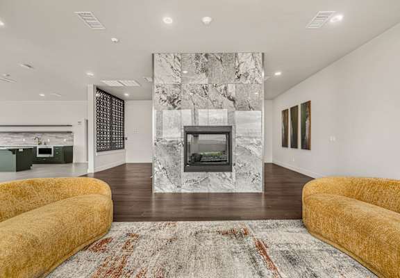 A living room with a fireplace and a rug.