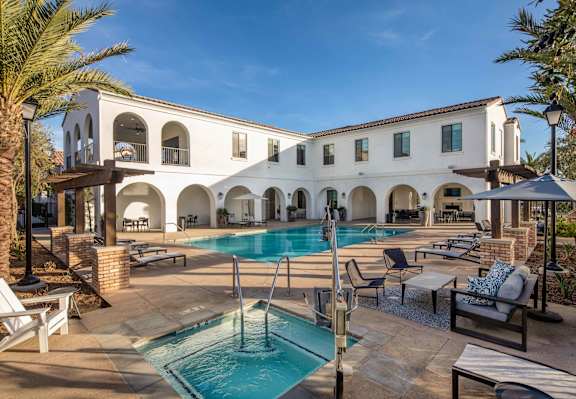 a girl in a pink bikini sitting on the edge of a pool at San Carlo Townhomes, Highland, 92346