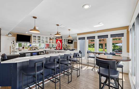 A bar with a counter and chairs is shown.