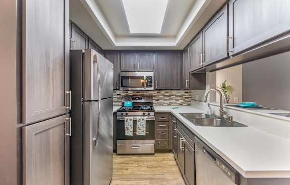 A modern kitchen with a white island and stainless steel appliances.