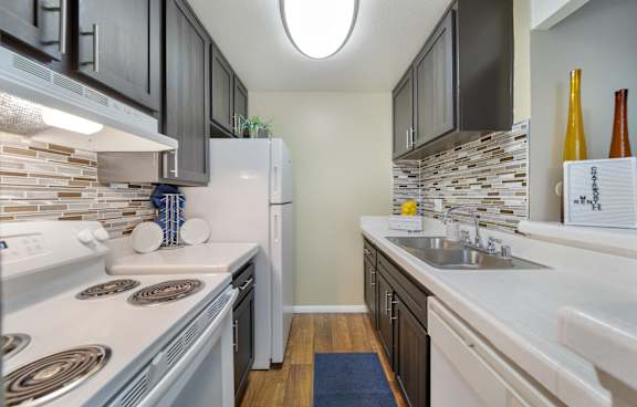 A modern kitchen with a white island and stainless steel appliances.