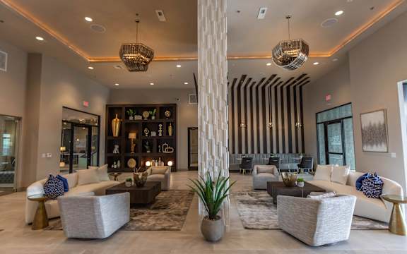 a living room with couches and chairs and a tall pillar