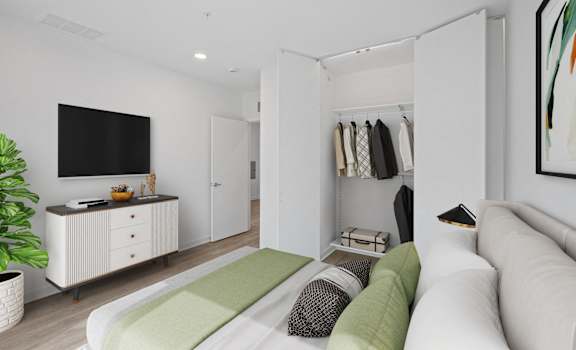 A living room with a white couch and a green cushion.