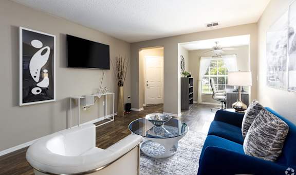 A modern living room with a white sofa and a glass coffee table.