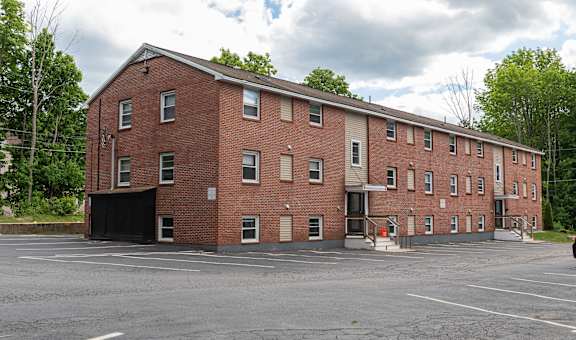 a large brick building with a parking lot in front of it