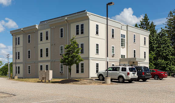 a large apartment building with a parking lot in front of it