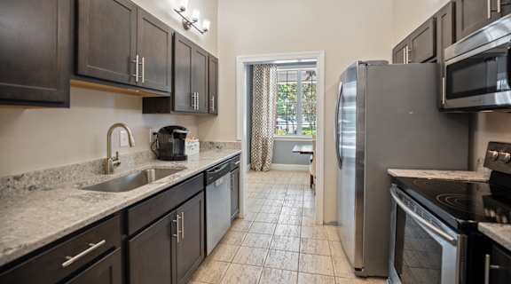 full kitchen with stainless steel appliances and granite counter tops and a window