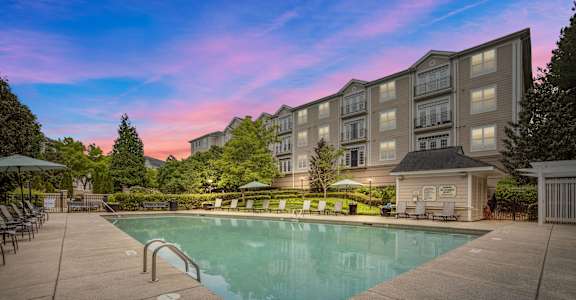 a swimming pool with an apartment building in the background