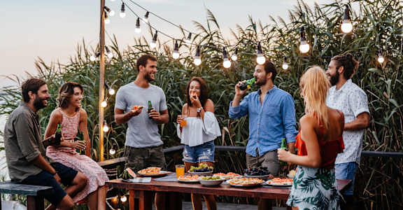 a group of people gathered around a table with food and drinks