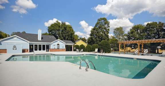 a swimming pool with a house in the background