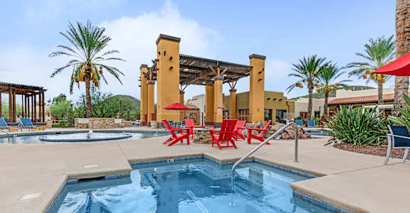 A pool with a blue water and a chair around it.
