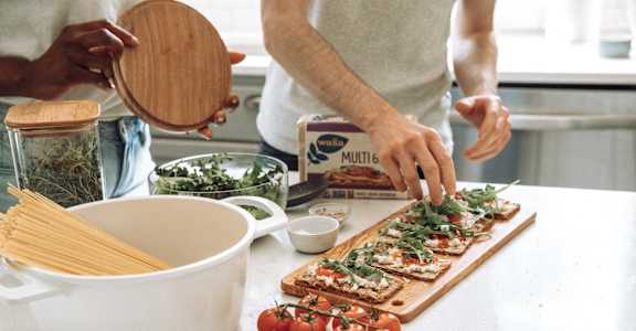 a person preparing food on a cutting board in a kitchen