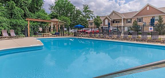 A swimming pool surrounded by a fence and trees.