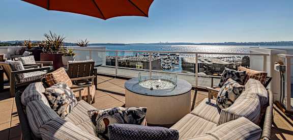 a seating area with a fire pit and a view of the water