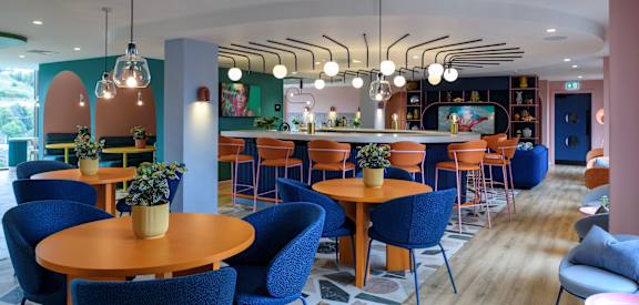 a restaurant with blue chairs and tables and a bar