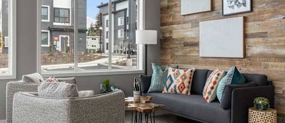 a living room with a couch and chairs in front of a large window