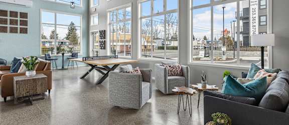 a living room with large windows and couches