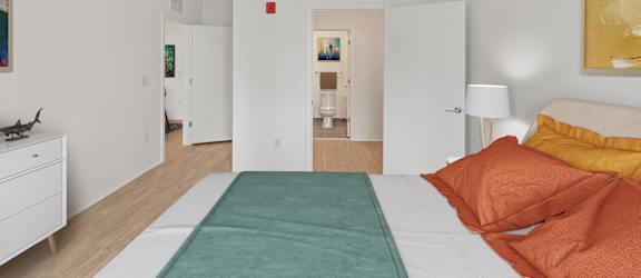 A bedroom with a bed, nightstand, and a painting on the wall.