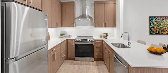 A modern kitchen with wooden cabinets and stainless steel appliances.