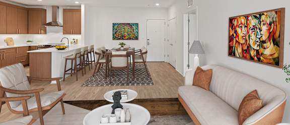 A modern living room with a white couch and a painting on the wall.