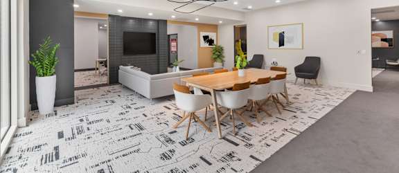A modern dining room with a large table and chairs.