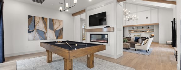 a living room with a pool table and a tv