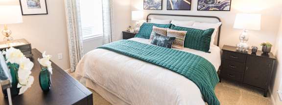 A bedroom with a large bed and a ceiling fan.