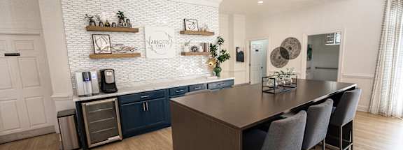 A kitchen with a long table and chairs.