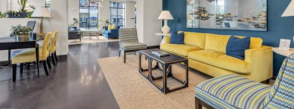 a living room with blue and yellow furniture and a table with chairs