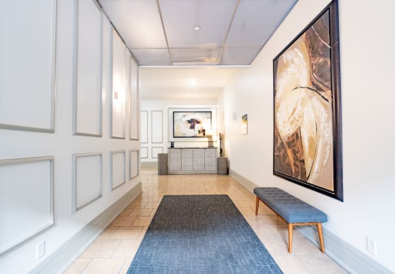 a view down a hallway with a bench and a large painting on the wall at 26 West, Managed by Buckingham Urban Living, 26 West Washington Street, IN