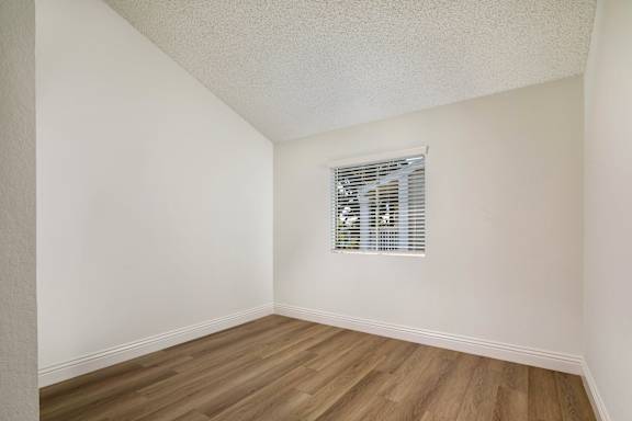 A room with a window and wooden flooring.