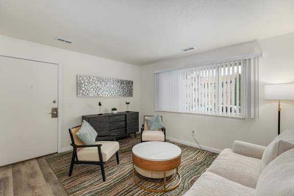 A living room with a white sofa, a wooden coffee table, and a grey couch.