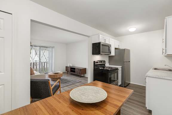 A kitchen with a table and chairs in the foreground.