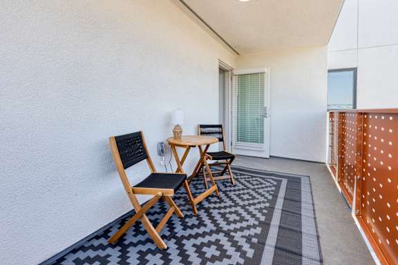 A small balcony with a table and chairs.